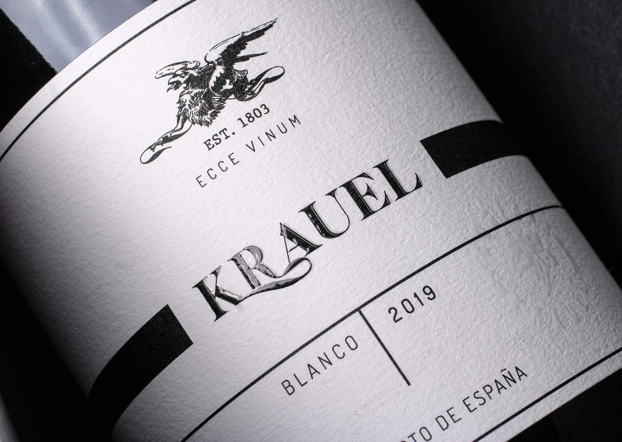 Detalle técnico de relieve con barniz serigráfico en etiqueta de vino premium para marketing háptico.